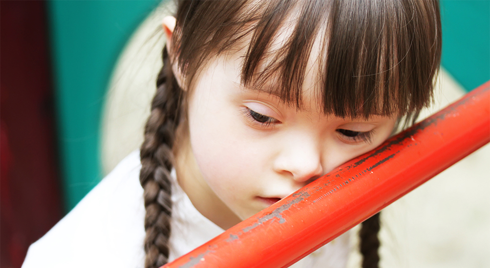 sad child leaning on railing