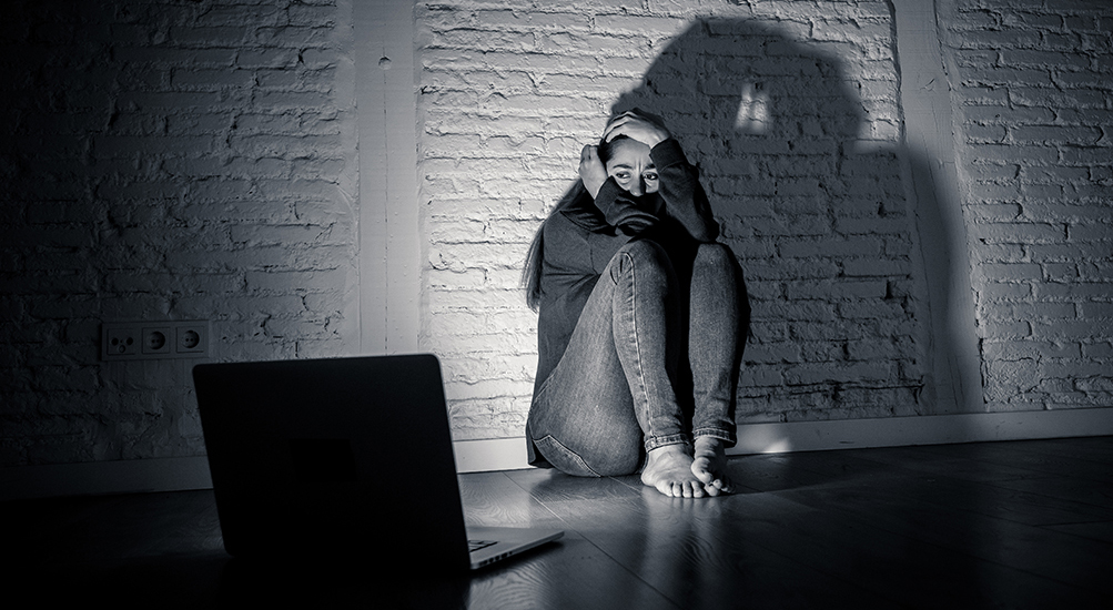 scared woman backing away from a computer