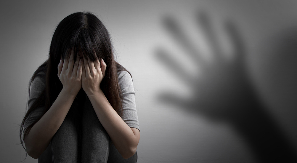 woman sitting and hiding her face with her hands